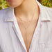 Diamond Pillow Lariat Necklace in 14k yellow gold styled on neck of model with layered necklace