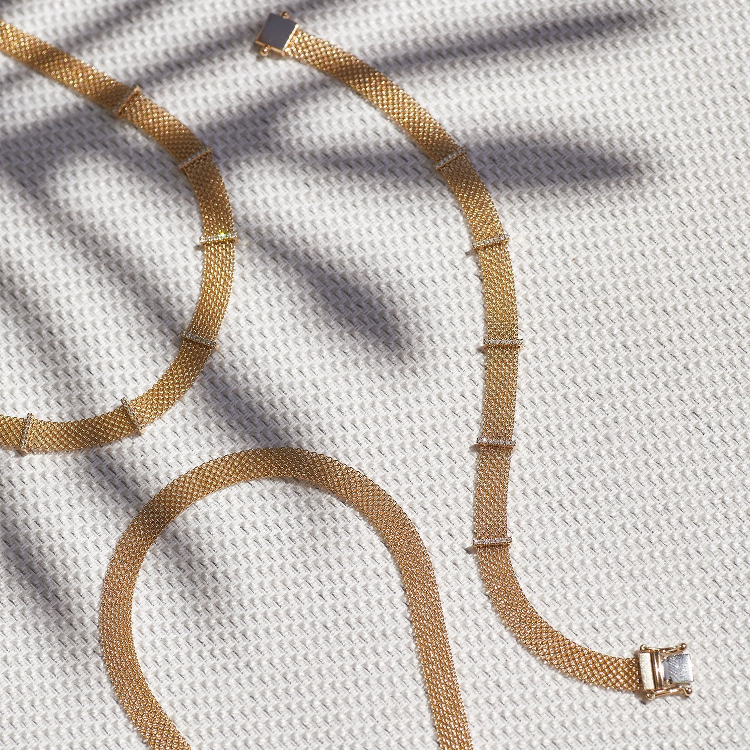 Gold Mesh Necklace in 14k yellow gold next to diamond bar necklace and diamond bar bracelet with palm tree shadow
