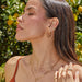 Emerald Wild Palm Stud Earring in 14k yellow gold styled on ear of model with multiple earrings